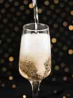 Free photo champagne pouring in glass with foam