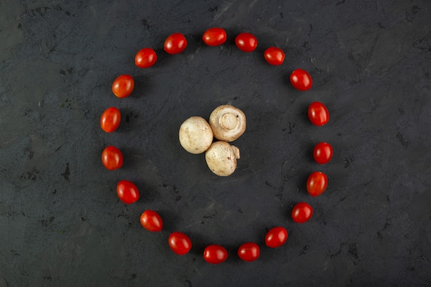 Champignons and tomatoes ripe champignons along with round shaped mellow cherry tomatoes on grey floor