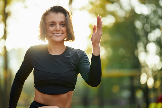 Charming active woman doing physical activity at city park