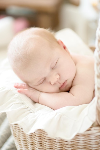 Charming baby sleeping wicker stroller closeup