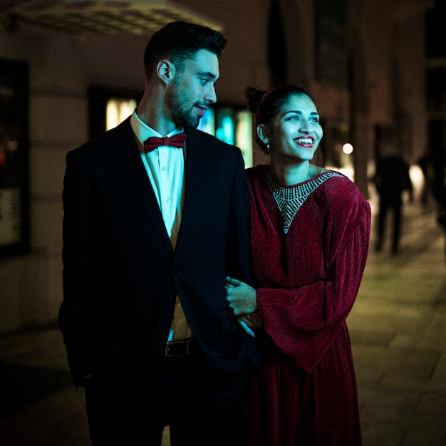 Charming beautiful smiling lady walking with young guy on street