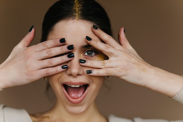 Free photo charming black-haired girl posing with surprised smile. attractive young woman with dark hair laughing