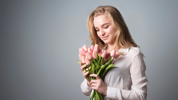 Charming blonde enjoying bunch of flowers