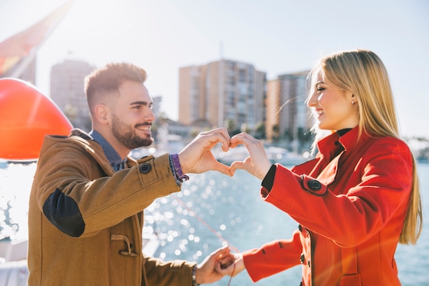 Charming couple showing heart with hands