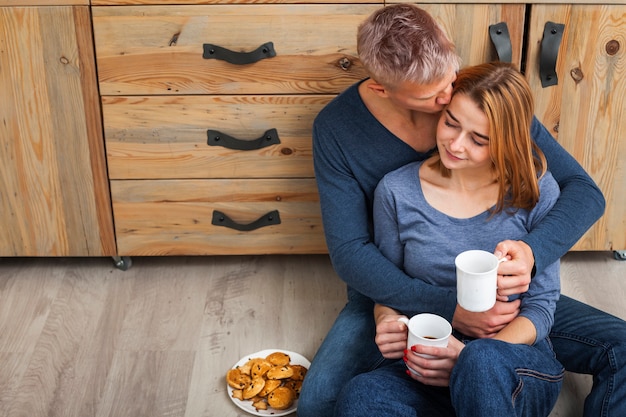 Charming couple sitting on the kitchen floor