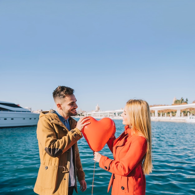 Free photo charming couple with romantic balloon outside