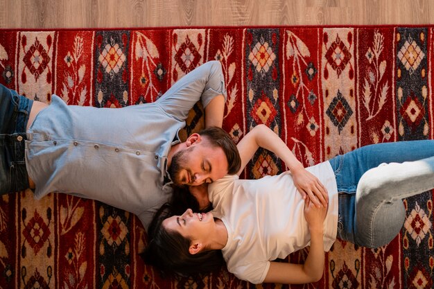 Charming couple of young beautiful lovers on carpet