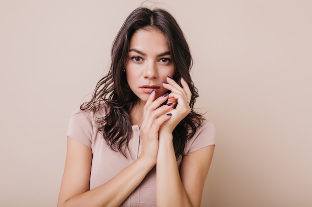 Charming girl with long eyelashes. Closeup portrait of brunette with beautiful purple manicure.