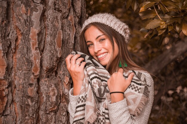 Charming lady near tree trunk