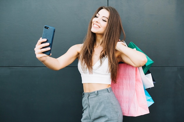 Charming model taking selfie with buying