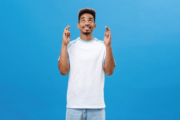 Charming optimistic african american man asking god help him waiting pleased and happy darkskinned j...