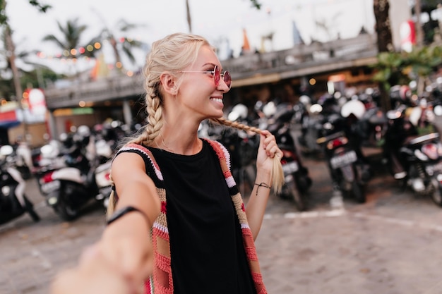 Free photo charming stylish girl wears black attire and pink sunglasses.