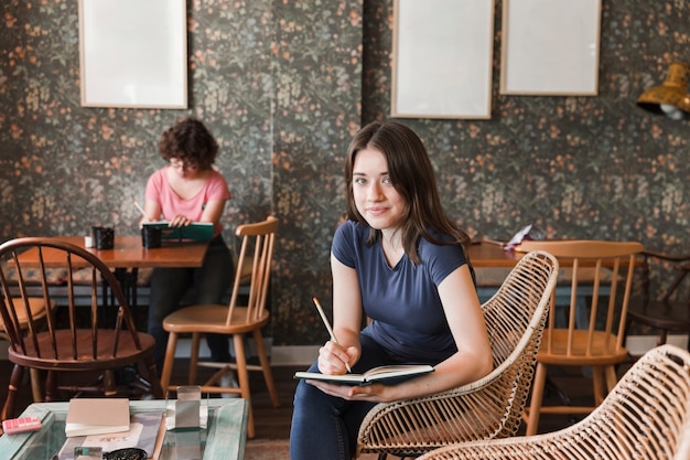 Charming teen girl with notebook in cafe