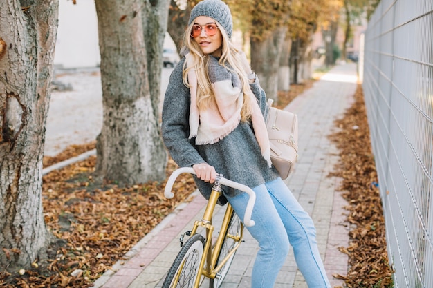 Free photo charming woman on bicycle near fence