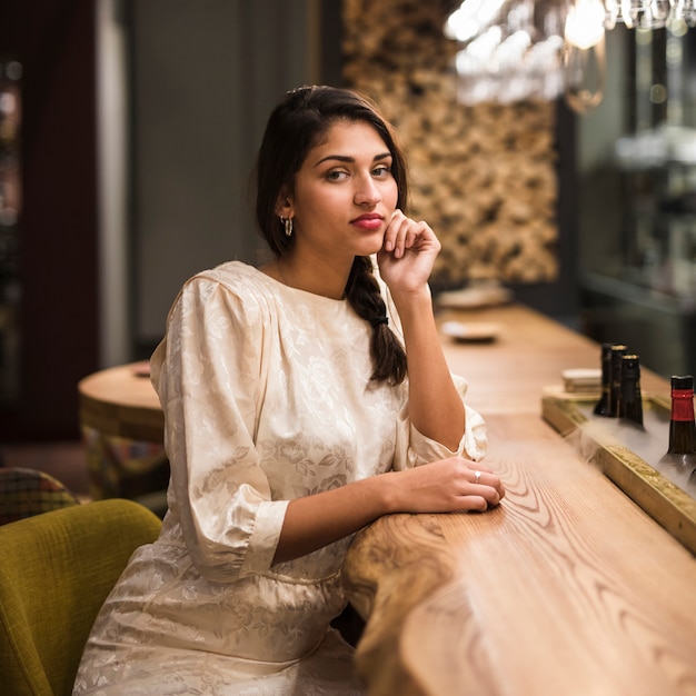 Charming woman sitting at bar counter