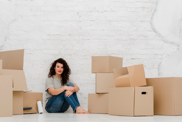 Free Photo charming woman sitting near boxes