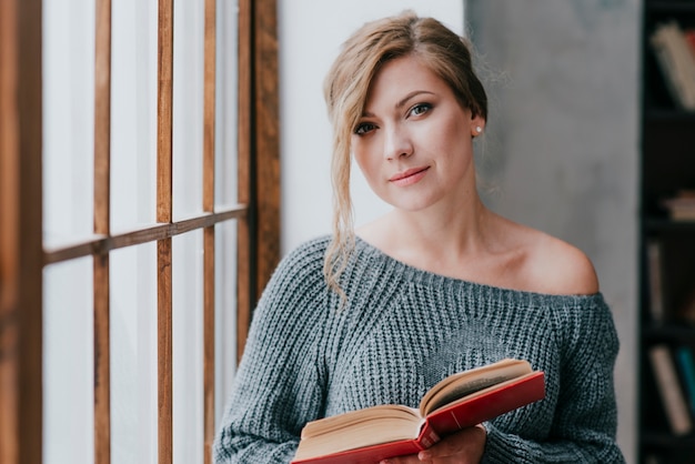 Free photo charming woman with book looking at camera