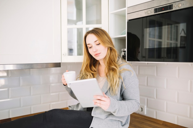 Free photo charming woman with tablet and mug