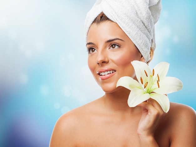 Charming woman with white lily wearing towel on head