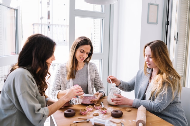 Free photo charming women decorating desserts