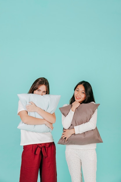 Free photo charming women embracing pillows