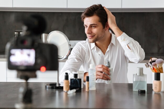 Charming young man filming his video blog episode