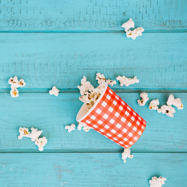 Free Photo checkered cup and spilled popcorn