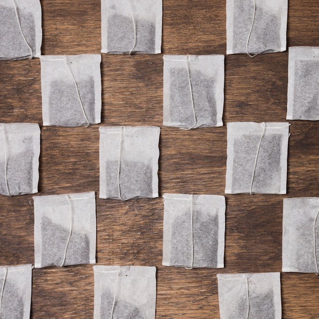 Free Photo checkered tea bag on wooden textured background