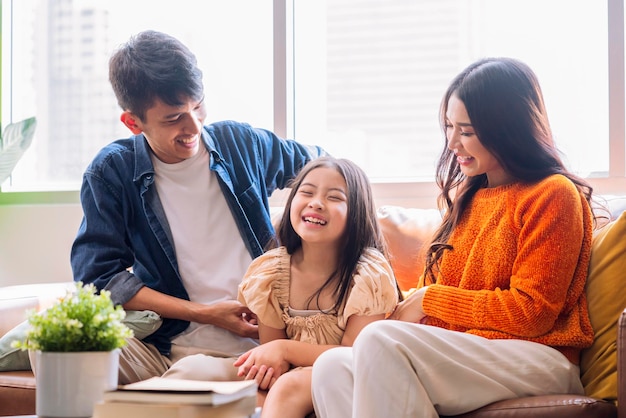 cheerful asian family play tickle parent daughter laugh smiling fun happiness together on sofa in living roomrelax casual family activity after packing stuff for home moving finish home moving ideas