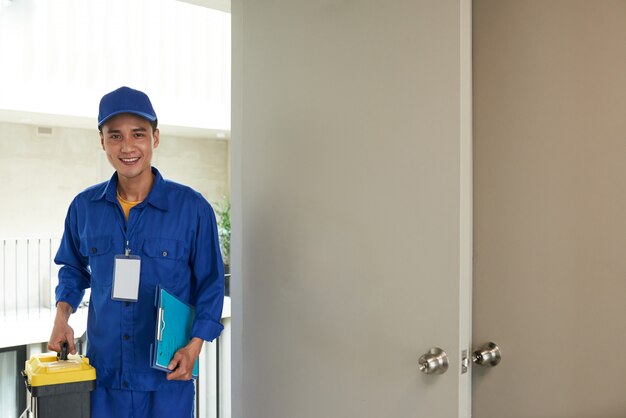 Cheerful Asian handyman arriving on house call