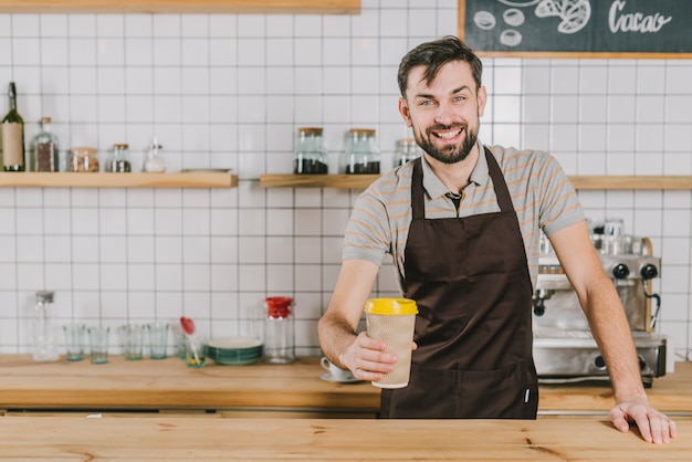 Cheerful barista with cup