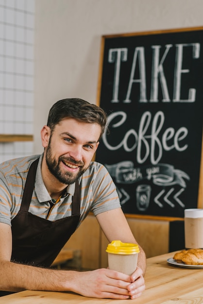 Cheerful barista with hot drink