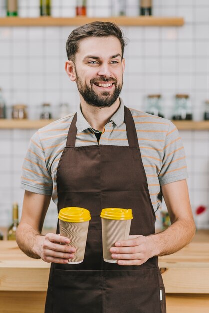 Cheerful bartender with hot beverages