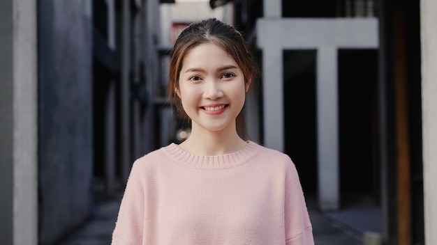 Cheerful beautiful young Asian woman feeling happy smiling to camera while traveling at Chinatown in Beijing, China. 