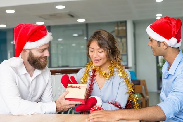 Cheerful boss giving Christmas gifts to employees