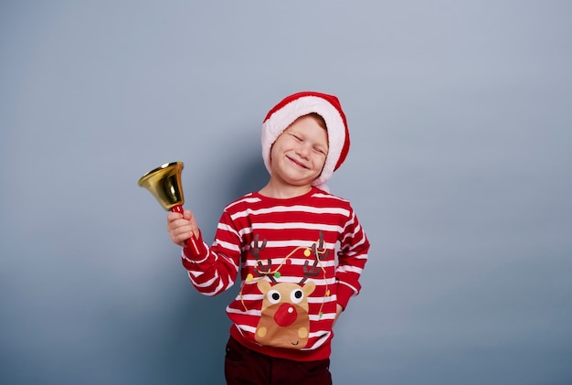 Free photo cheerful boy with handbell at studio shot