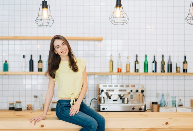 Free photo cheerful brunette on bar counter