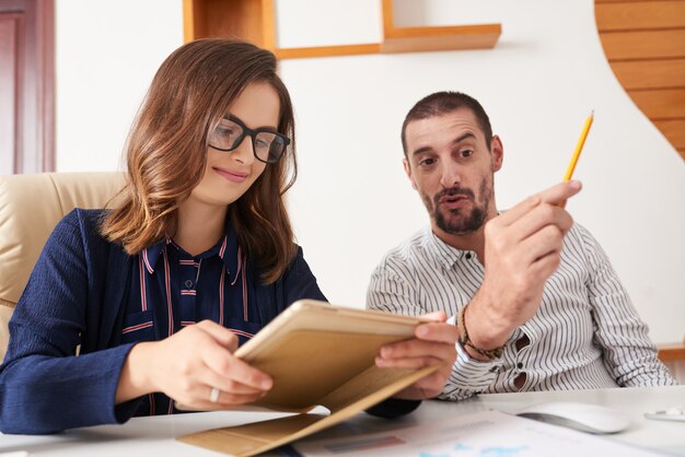 Cheerful business lady reading report on tablet