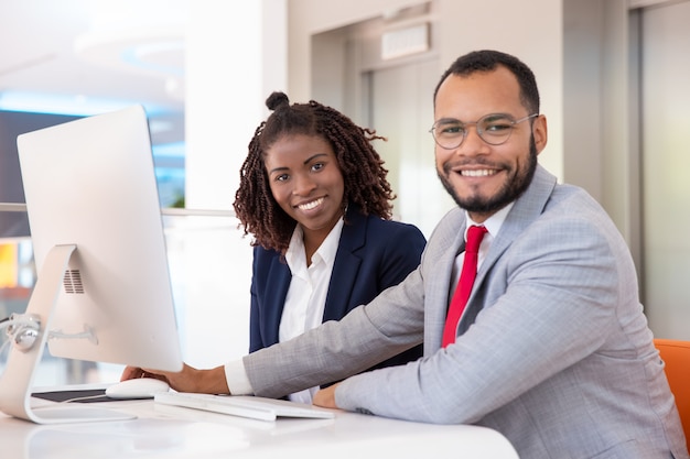 Cheerful business people using desktop computer