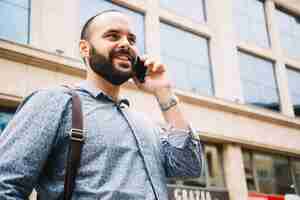 Free photo cheerful businessman talking on smartphone