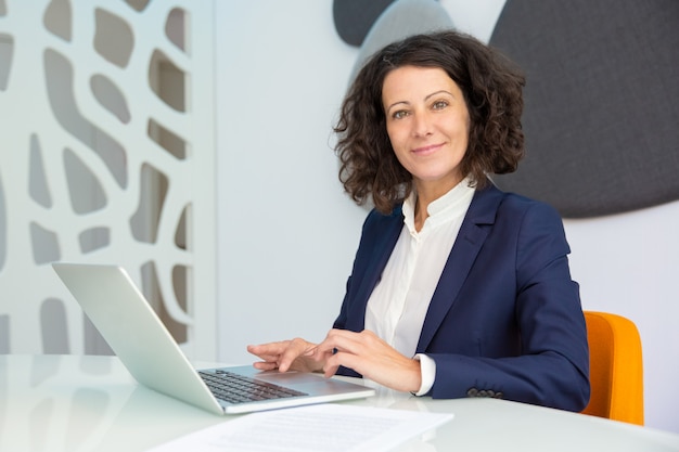 Cheerful businesswoman using laptop