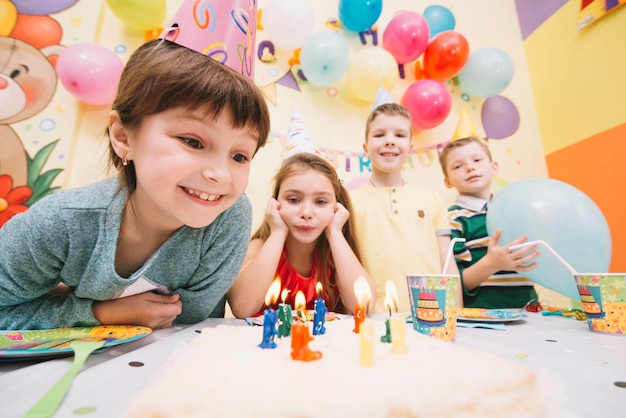 Cheerful children looking at birthday cake