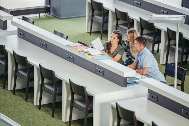 Free photo cheerful college classmates in library