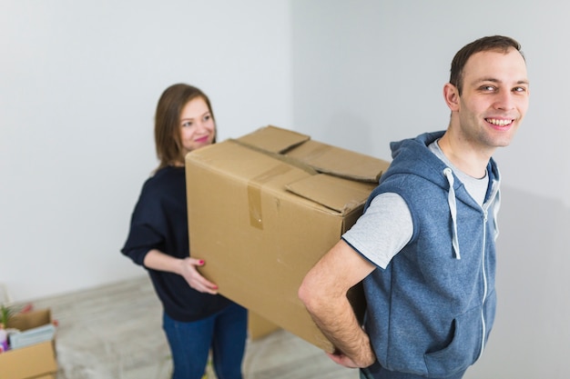 Free Photo cheerful couple carrying box