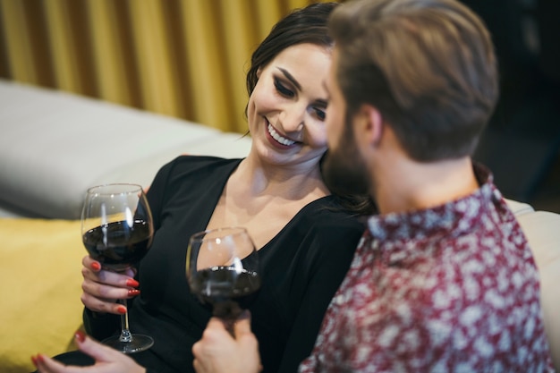 Free photo cheerful couple enjoying wine at home