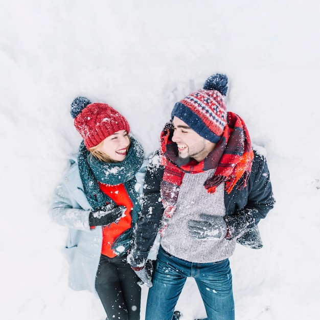 Cheerful couple lying in snow