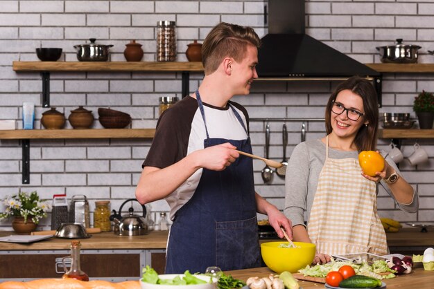 Cheerful couple during salad preparation