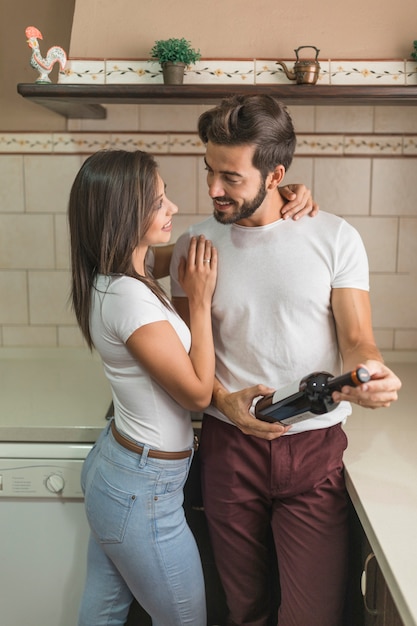 Cheerful couple with wine in kitchen