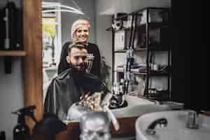 Free photo cheerful customer and barber in shop