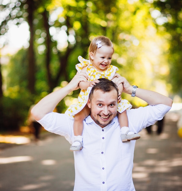 Free photo cheerful dad holds his daughter on the neck